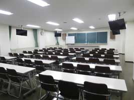 茨城県立青少年会館の中研修室2。演台と机の配置が見える別角度の室内写真。