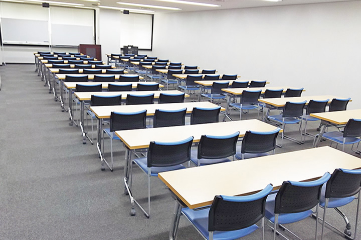 机と椅子がスクール形式で配置された501号室の室内。