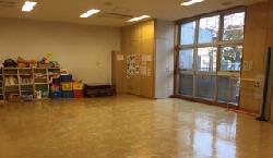 児童室。遊具棚とマットのある室内。