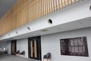 鯖江市文化センターのホワイエ。ホール入口と木製の壁面が見える。
