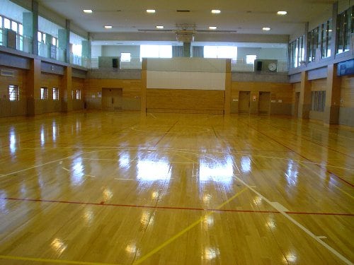体育館。コートとステージを備えた無人の室内全景。
