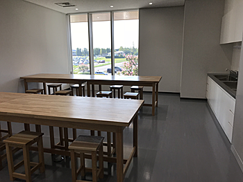 白岡市生涯学習センター（こもれびの森）の創作室。作業机と流し台のある室内。