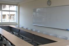 エルセンターの中会議室。窓際に机と椅子が配置されている。