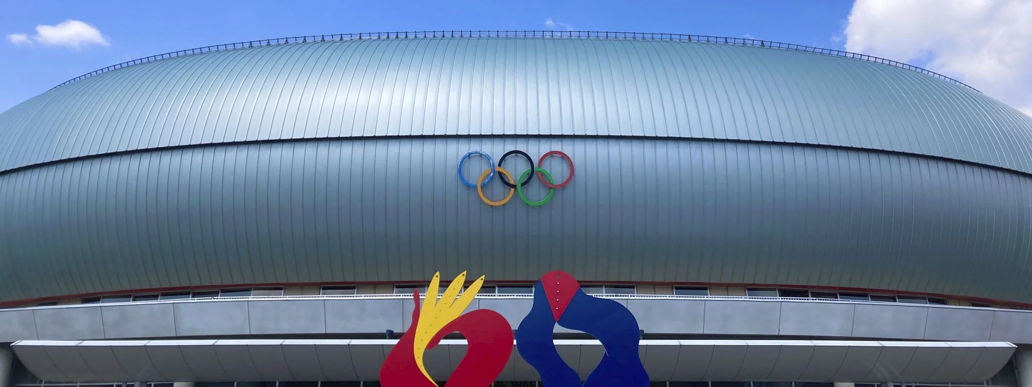 ホワイトリング（長野市真島総合スポーツアリーナ）の屋根と五輪マークの外観（公式サイト掲載）