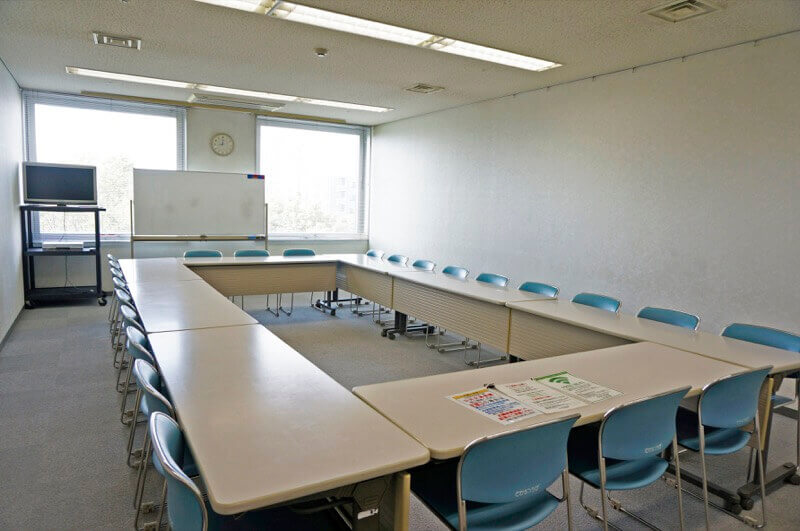 会議室305。ロの字形式に机と椅子が配置されている。