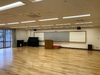 多目的室。広い床面と壁面スクリーンが見える。