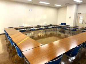 無人の第5会議室。机と椅子がロの字型に配置された室内。