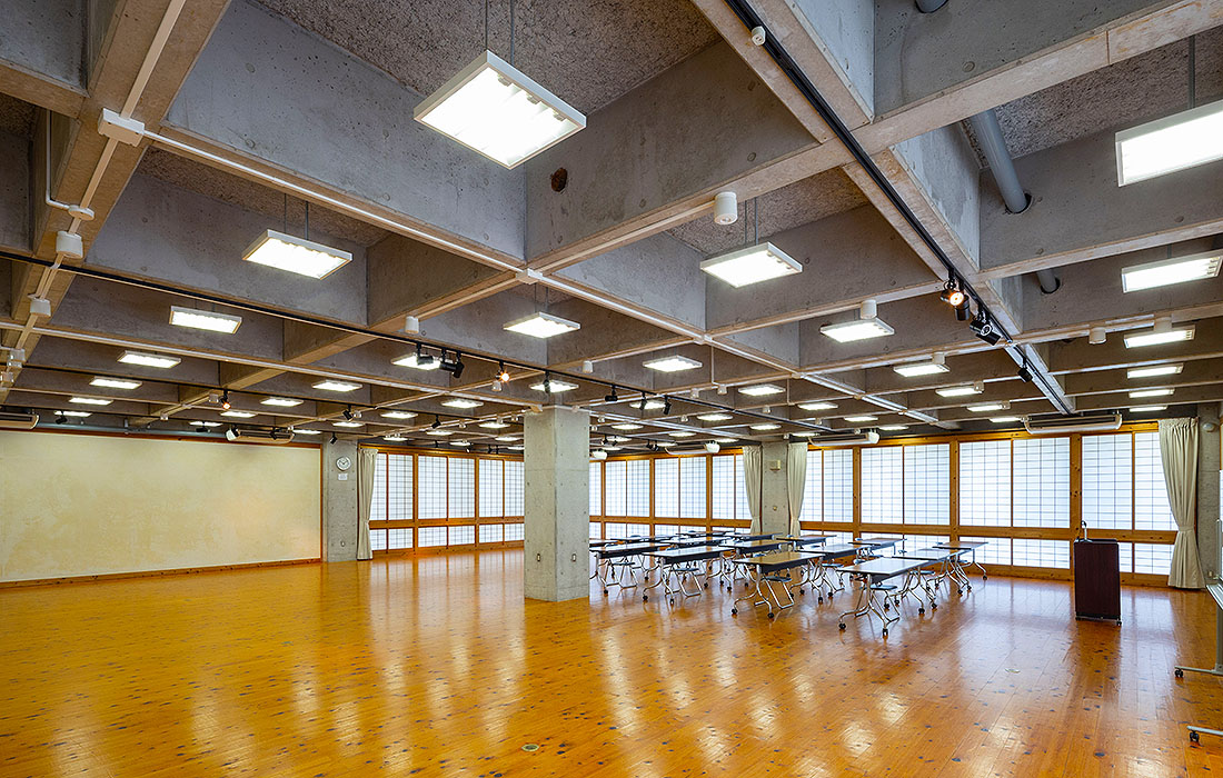 机と椅子を配置した1階多目的ホールを別の角度から見た室内。