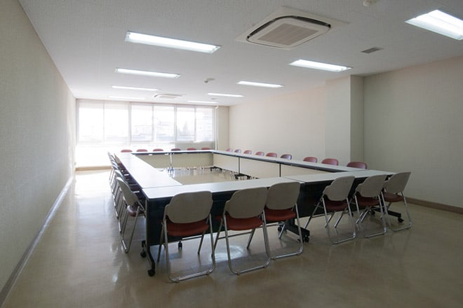 小会議室1。会議用テーブルと椅子が配置された室内。