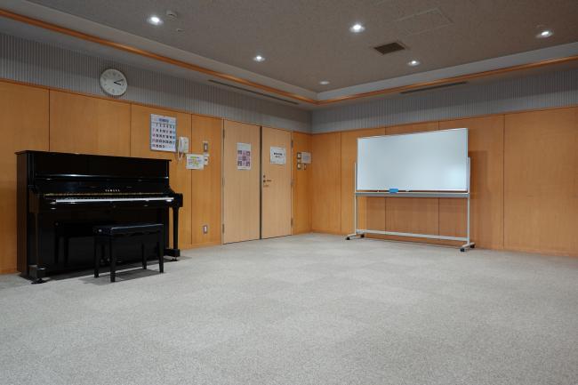 音楽室。ピアノとホワイトボードを備えた室内。