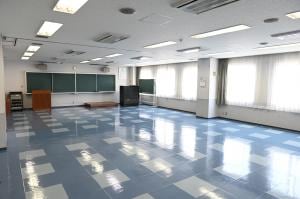 中会議室。机と椅子、黒板を備えた無人の室内。