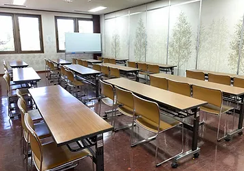 甚目寺産業会館の大研修室（第2）。窓際に机と椅子が並ぶ室内。