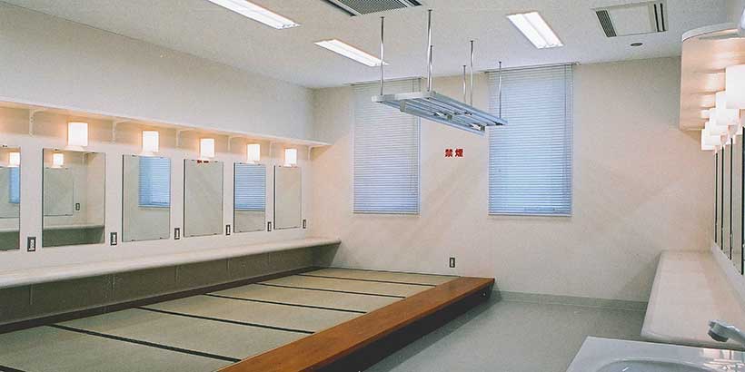 北文化小劇場の楽屋。鏡と洗面台、長椅子を備えた室内。