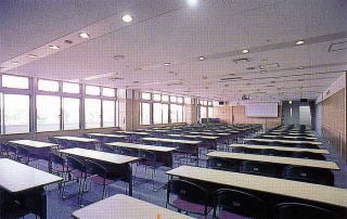 会議室1。多数の机と椅子が並ぶ室内全景。
