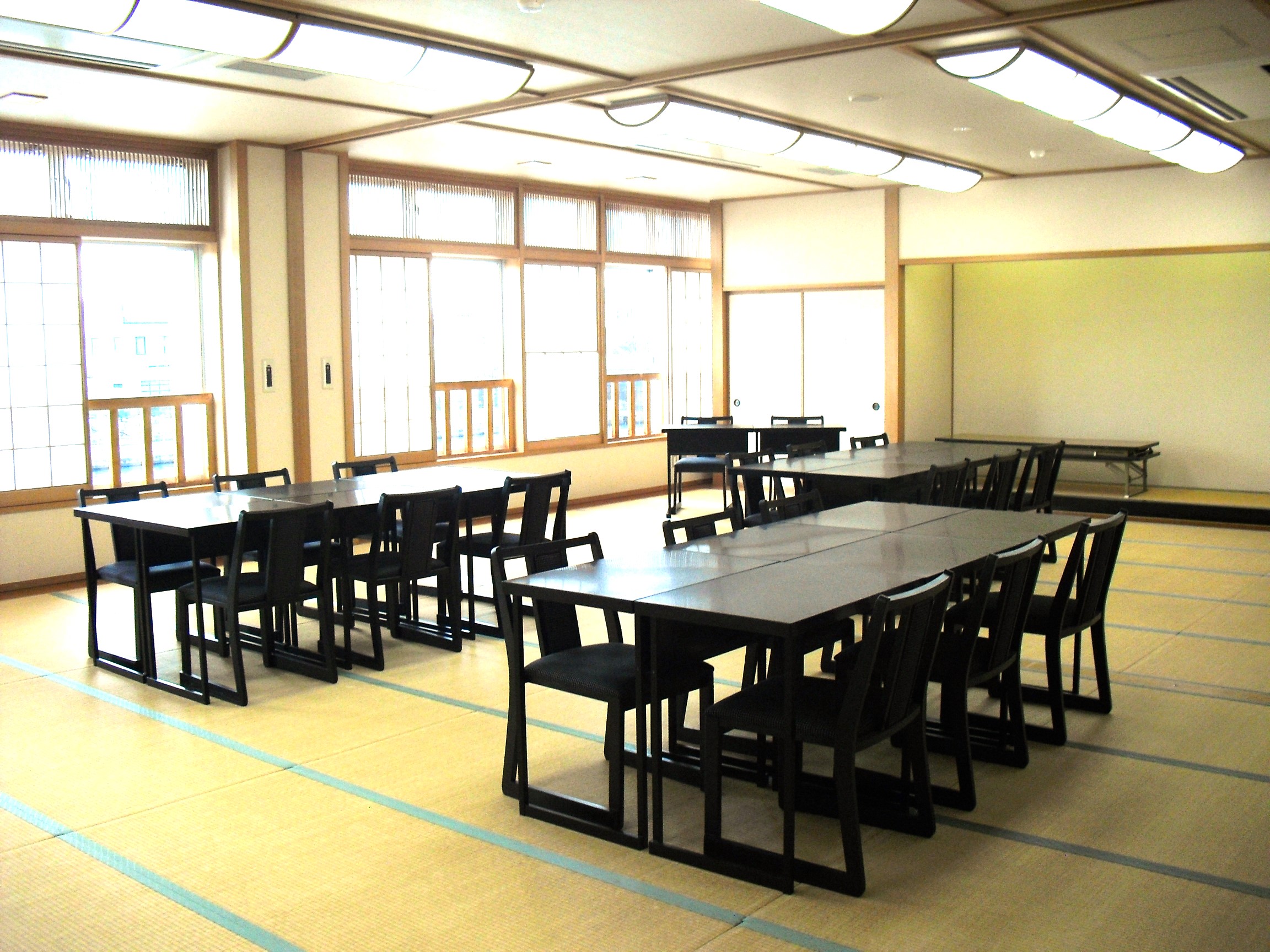 別館の和室中研修室。机と椅子を配置した室内。