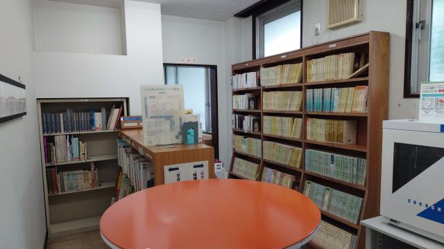 三日月橋生涯学習センターの図書室。書棚と中央の丸テーブルが見える。