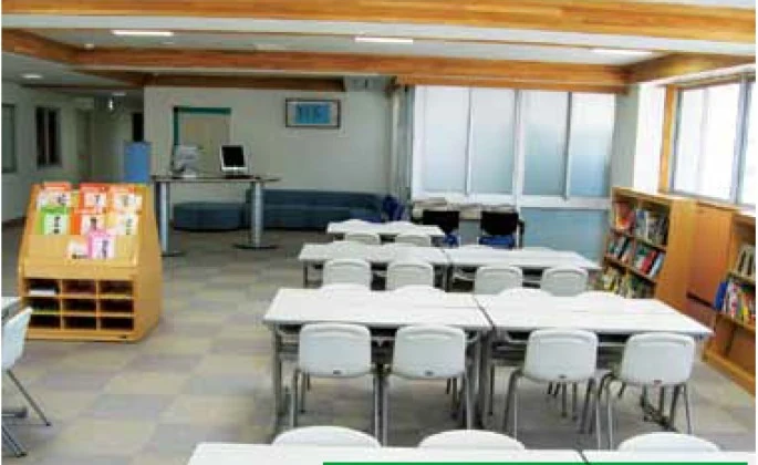 碧南市ものづくりセンター 産業情報コーナー。テーブル、椅子、書棚のある明るい室内