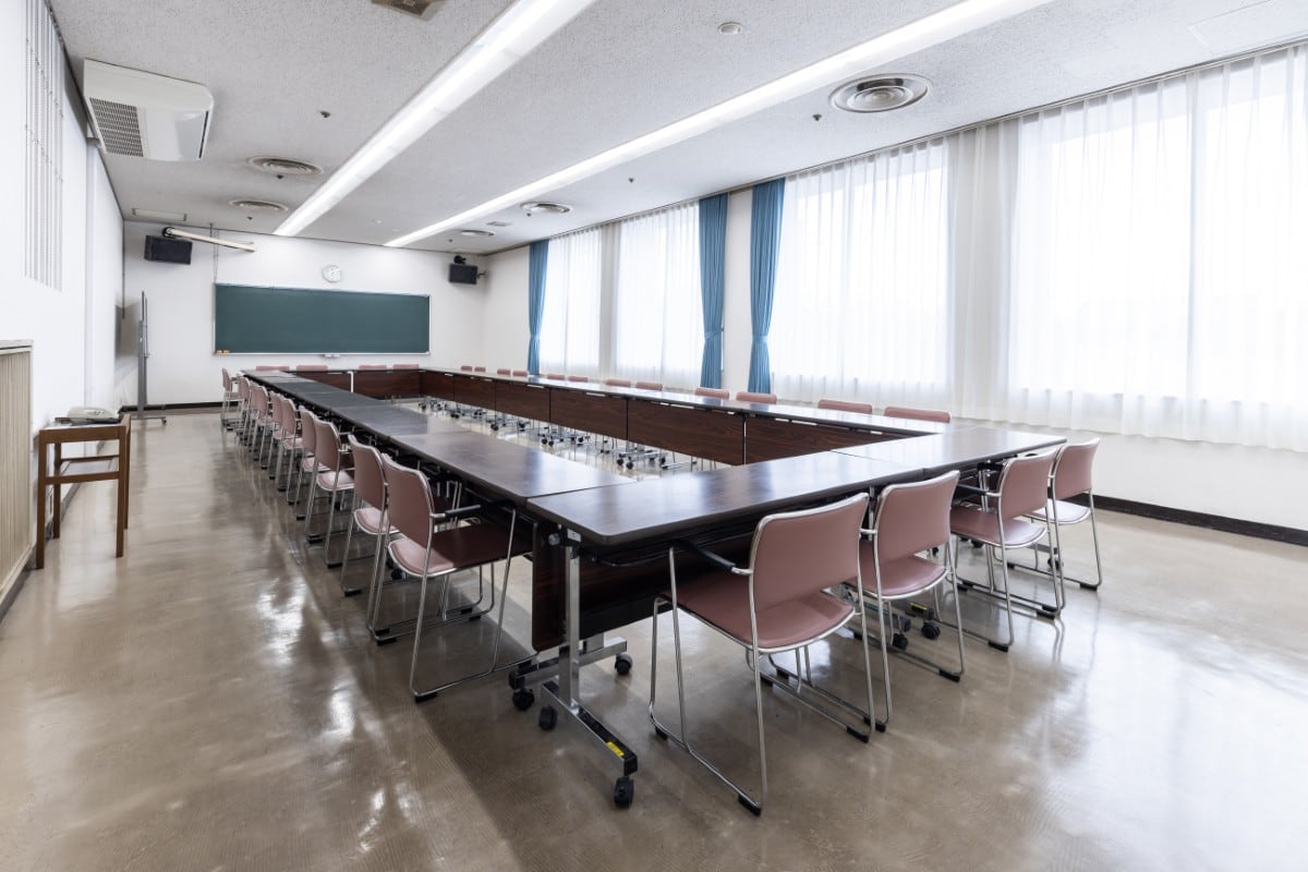 第1・第4会議室。机と椅子がロの字型に配置された室内。