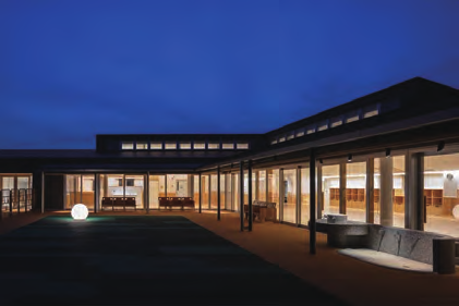 可児市子育て健康プラザmanoの館内中庭。夕方に照明がついた建物内側の空間。