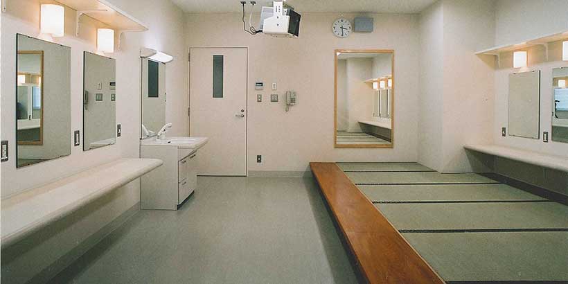 北文化小劇場の別の楽屋。鏡と洗面台、長椅子を備えた室内。