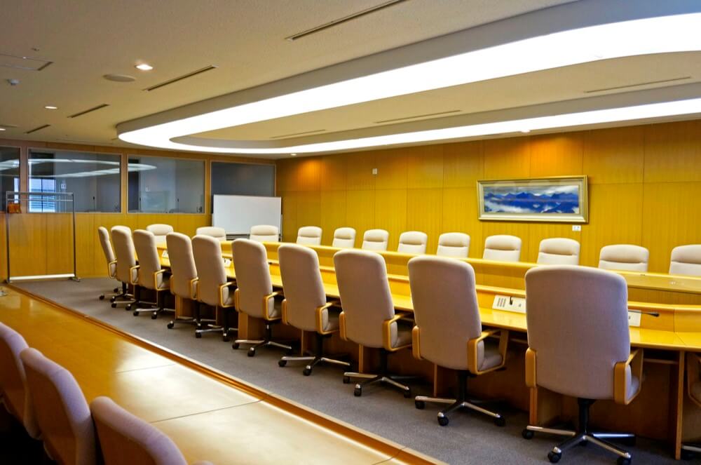 特別会議室。円卓形式の会議テーブルと椅子が配置されている。