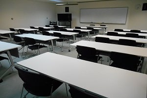 和歌山市勤労者総合センターの視聴覚室。机と椅子、映像設備が見える。
