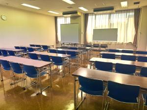 無人の第6会議室。机と椅子がスクール形式に並ぶ室内。
