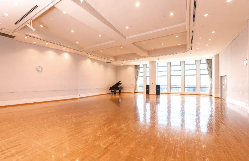 大練習室。広いフローリングの室内にグランドピアノと大きな窓がある。