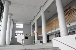 鯖江市文化センターのホワイエ。吹き抜けと階段、柱が見える。