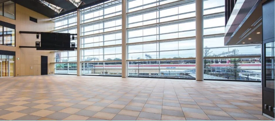 あかし市民広場の屋内イベントスペース。駅側の大窓と広い床面が見える市公式パンフレット掲載写真