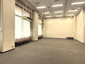 無人の第1展示室。窓際にベンチのある展示・会議向け室内。
