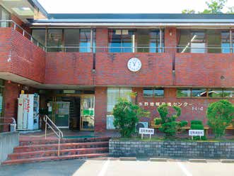 水野地域交流センター（まほろば館）の正面外観。入口と植栽が見える。