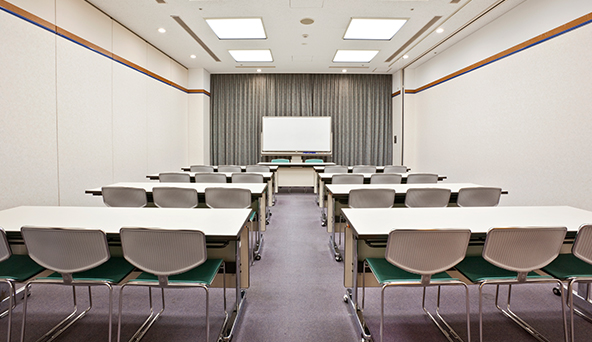 サンメッセ香川の小会議室。会議用の机と椅子が並ぶ室内。