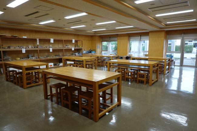 工芸室。作業台と収納棚が並ぶ創作活動向けの室内。