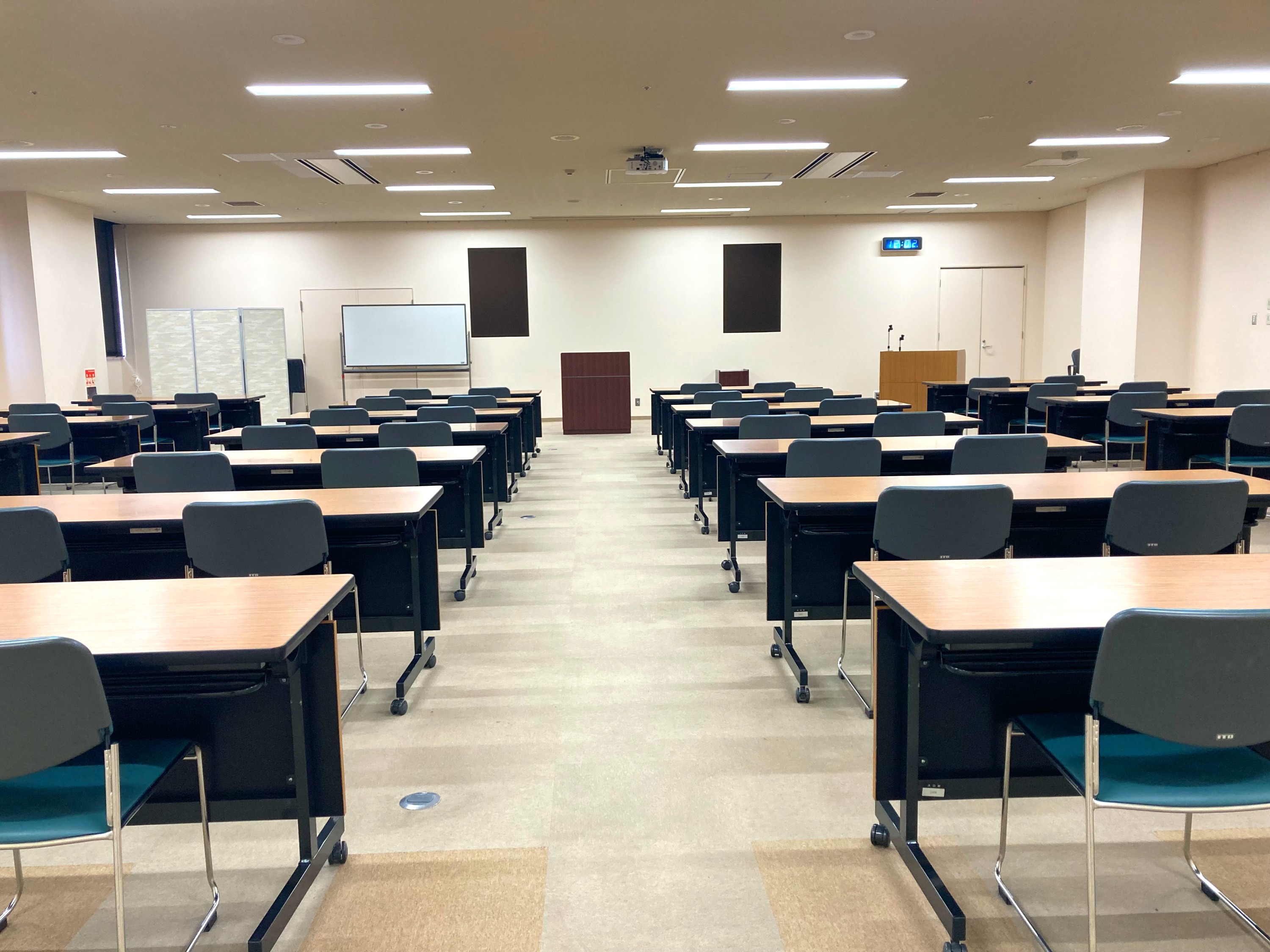 机と椅子が並ぶ研修センターの大人数向け会場